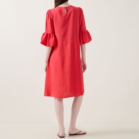 Model wearing InWear Reese Flared Dress in red with flared cuffs, keyhole back, and knee length, styled with white flat sandals.