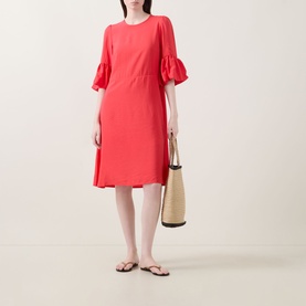 Model wearing InWear Reese Flared Dress in red with flared cuffs and knee-length hem, styled with a woven tote bag and flip flops.