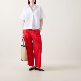Model wearing InWear Elvia Wide-Leg Cropped Trousers in red, styled with a white short-sleeve shirt and black flats, carrying a cream tote bag.