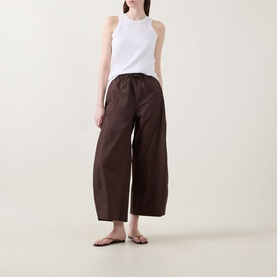 Model wearing InWear Raven Wide-Leg Trousers in dark brown with white sleeveless top and flat sandals