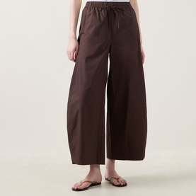 Model wearing InWear Raven Wide-Leg Trousers in dark brown with elasticated drawstring waist, styled with tan flat sandals