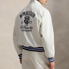 Model wearing white Polo Ralph Lauren Wimbledon bomber jacket, navy graphic back print, striped ribbed cuffs and hem