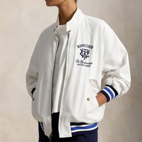 Model wearing white bomber jacket with navy Wimbledon graphic, striped cuffs, styled over white tee