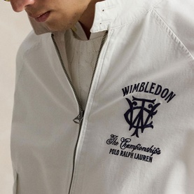 Model wearing white zip-up jacket with navy Wimbledon The Championships Polo Ralph Lauren embroidered logo on chest