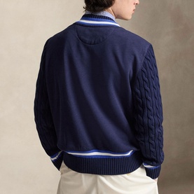 Model wearing Ralph Lauren Wimbledon Logo Hybrid Sweater in Refined Navy, showing rear view with cable-knit sleeves and striped rib-knit hem