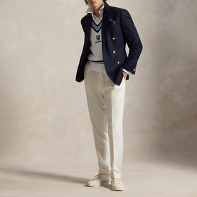 Model wearing Ralph Lauren Wimbledon Logo Cricket Knitted Sweater Vest in cream, styled with navy blazer, white shirt, and cream trousers.