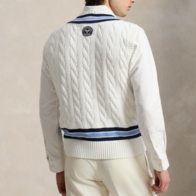 Model wearing Ralph Lauren Wimbledon Logo Cricket Knitted Sweater Vest in cream, cable-knit back with navy stripe hem and Wimbledon patch at neck.