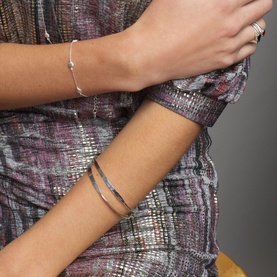 Model with Juvi Hammered Bangle in silver sterling silver with hammered texture finish, styled with a second delicate bracelet