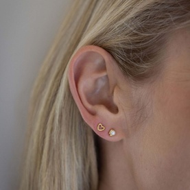 Model with Juvi Forever Heart Stud Earrings in gold, heart-shaped gold-plated sterling silver studs worn on ear