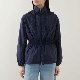 Model wearing Moncler Liriope Logo Raincoat in navy, featuring drawstring hood, elasticated waist and cuffs, styled with light blue jeans.