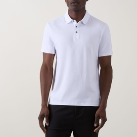 Model wearing Calvin Klein Monogram Logo Polo Shirt in Bright White, short sleeves, flat collar with button fastening and embroidered logo detail.