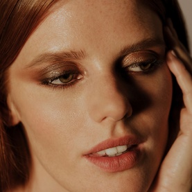 Model with Sisley Phyto-Eye Palette in Tender Toffee, warm bronze and khaki eye look with glowing skin and subtle coral lip