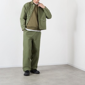 Model wearing Stone Island Verde Militare cotton sweatshirt, styled with olive jacket, matching wide-leg trousers and black loafers.
