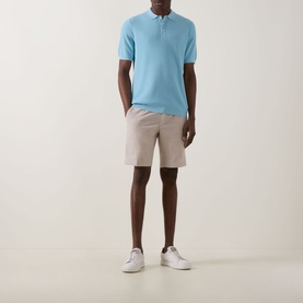 Model wearing Bugatti Structure Polo Shirt in aqua with ribbed trims, styled with stone chino shorts and white trainers.