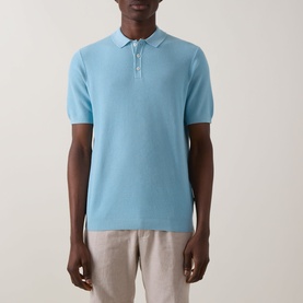 Model wearing Bugatti Structure Polo Shirt in aqua, short sleeves, flat collar with button fastening, styled with light linen trousers.