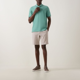Model wearing Bugatti Double Tipped Logo Polo Shirt in mint with beige chino shorts and brown loafers.