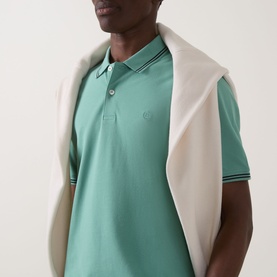 Model wearing Bugatti Double Tipped Logo Polo Shirt in mint, short sleeves with tipped collar and cuffs, styled with a cream knitwear draped over
