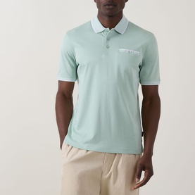 Model wearing Bugatti Patch Pocket Polo Shirt in mint, with tipped collar, chest patch pocket, and three-button placket, styled with beige trousers.