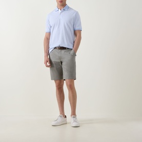 Model wearing Bugatti Stripe Logo Polo Shirt in light blue with grey chino shorts and white trainers.