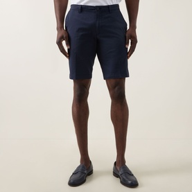 Model wearing Bugatti Twill Slim-Leg Shorts in navy, slim-leg cut above the knee, styled with brown loafers and white shirt