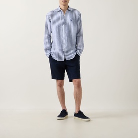 Model wearing Bugatti Lightweight Drawstring Shorts in navy linen-blend, styled with a white stripe shirt and navy canvas shoes.