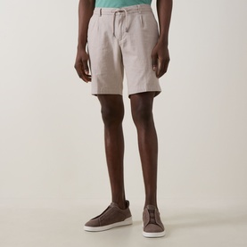 Model wearing Bugatti Lightweight Drawstring Shorts in stone linen-blend, styled with brown suede trainers and mint green polo shirt.