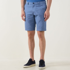 Model wearing Bugatti Summer Bermuda Shorts in light blue with belt loops and side pockets, styled with navy trainers.