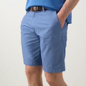 Model wearing Bugatti Summer Bermuda Shorts in light blue with brown leather belt, styled with blue top. Textured cotton finish with belt loops.
