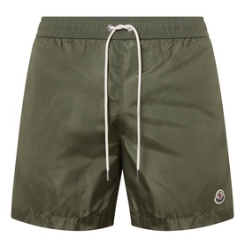 Moncler green swim shorts with white drawstring waistband and logo badge on left leg, lightweight polyamide fabric