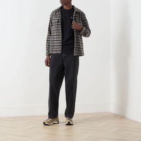 Model wearing Dickies Fairlawn Graphic T-Shirt in black, styled with checked overshirt and dark tapered trousers.