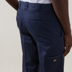 Model wearing Dickies 247 Loose Work Trousers in Navy Blue, showing rear welt pockets and woven logo label detail.
