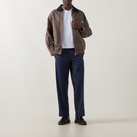 Model wearing Dickies 247 Loose Work Trousers in Navy Blue, straight-leg fit, styled with a brown zip-up jacket and white tee.