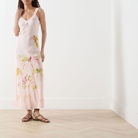 Model wearing Hayley Menzies Palmera Silk Slip Dress in pink with tropical palm print, cutwork embroidery, V-neck; styled with brown flat sandals