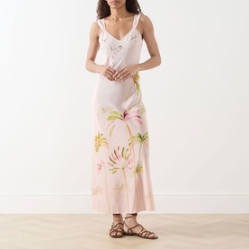 Model wearing Hayley Menzies Palmera Silk Slip Dress in pink with tropical floral print and cutwork embroidery, styled with brown flat sandals.