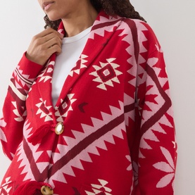 Model wearing Hayley Menzies Sundance Printed Cardigan in red with geometric tapestry motifs, shawl collar and gold button fastening, styled over