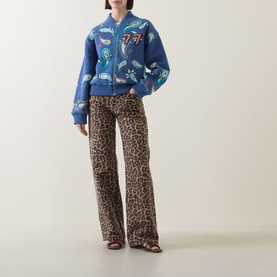 Model wearing Hayley Menzies Jimi Bandana Print Bomber Jacket in blue with leopard print wide-leg trousers and strappy heeled sandals.