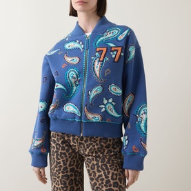 Model wearing Hayley Menzies Jimi Bandana Print Bomber Jacket in blue paisley with cropped length, styled with leopard-print trousers.