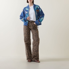 Model wearing Hayley Menzies Jimi Bandana Print Bomber Jacket in blue with leopard-print flared trousers and red strappy sandals.