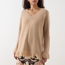 Model wearing Hayley Menzies Fringe Cashmere Sweater in camel, featuring V-neckline, long sleeves, and fringed hem trim.