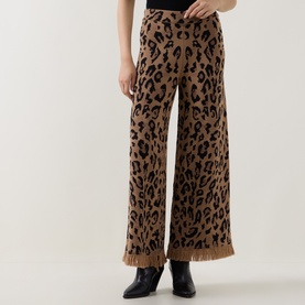Model wearing Hayley Menzies Cosmic Cat trousers in leopard jacquard with fringe hem, styled with black ankle boots.