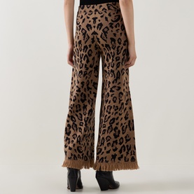 Model wearing Hayley Menzies Cosmic Cat trousers in leopard jacquard knit with wide-leg silhouette and fringe hem detail.