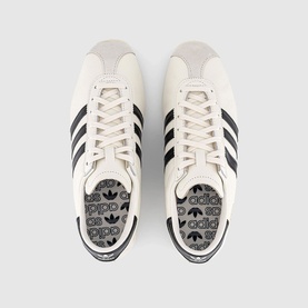Adidas trainers in core white with black three-stripe detail, lace-up front, logo insole, overhead flat lay view