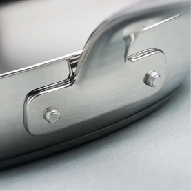 Tramontina silver stainless steel frying pan lid, close-up of brushed metal handle with bolt detail