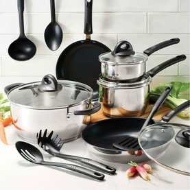 Tramontina silver stainless steel cookware set with glass lids, non-stick frying pans, and black utensils on kitchen counter