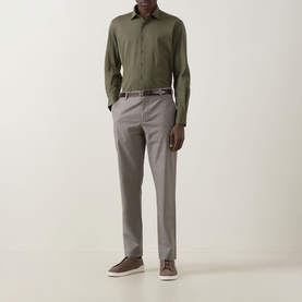 Model wearing Rodd & Gunn Ascot Park Shirt in khaki with grey tailored trousers and brown leather trainers.