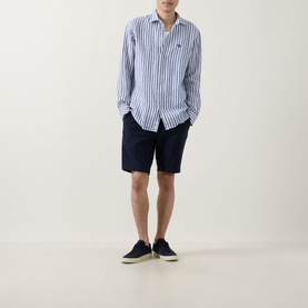 Model wearing Rodd & Gunn Seadown Stripe Shirt in French navy, paired with navy shorts and dark canvas shoes.