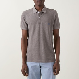 Model wearing Rodd & Gunn The Gunn Polo Shirt in Mocha, short sleeves, flat collar with button fastening, paired with light blue trousers