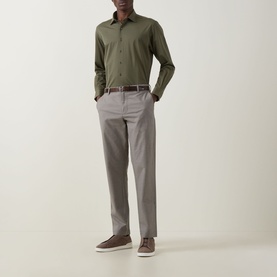 Model wearing Rodd & Gunn Gunn Straight Leg Chinos in Latte with belt loops, styled with olive shirt and brown trainers.