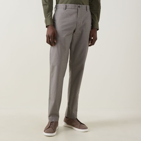 Model wearing Rodd & Gunn Gunn Straight Leg Chinos in Latte, styled with a green shirt and taupe loafers.