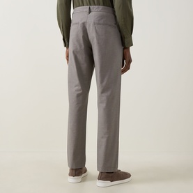 Model wearing Rodd & Gunn Gunn Straight Leg Chinos in Latte, rear view showing belt loops and jet pockets, styled with white trainers and olive shirt